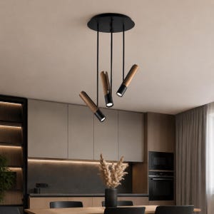 May include: A three-light pendant fixture featuring a circular black ceiling canopy with three thin black rods extending downward. Each rod holds a cylindrical light head with a dark wood grain finish and a black base, emitting a focused light.