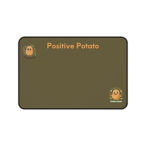 以下が含まれることがあります： 茶色の背景と黒い縁取りの長方形のマウスパッド。「Positive Potato」の文字がオレンジ色で印刷されています。マウスパッドには、両側に1つずつ、2つの漫画のジャガイモのイラストがあり、それぞれの下に「Positive Potato」の文字があります。
