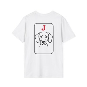Può includere: T-shirt bianca con grafica nera e rossa di un cane bassotto all'interno di una cornice rettangolare. La lettera "J" è sopra la testa del cane. Il disegno è sul retro della maglietta.