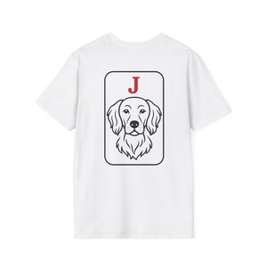 Può includere: T-shirt bianca con un'illustrazione in bianco e nero del muso di un cane all'interno di una cornice rettangolare. La lettera "J" rossa è stampata sopra l'illustrazione del cane. La maglietta è realizzata in un materiale morbido e confortevole.