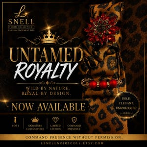 May include: A brown and black leopard print necktie adorned with a large red crystal flower brooch and a gold-toned safety pin featuring three red beads. The image includes text: L SNELL NOIRE COLLECTION, UNTAMED ROYALTY, WILD BY NATURE, ROYAL BY DESIGN, NOW AVAILABLE, BOLD, ELEGANT, UNAPOLOGETIC, 1 OF 1, SIGNATURE CUSTOM PIECE, LIMITED EDITION, COMMAND PRESENCE, COMMAND PRESENCE WITHOUT PERMISSION, LSNELLNOIRECOLL.ETSY.COM.