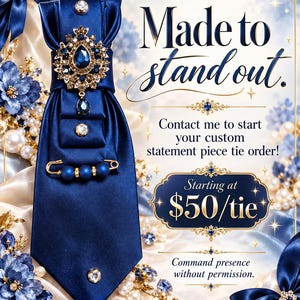 May include: A deep blue satin necktie adorned with a large central teardrop-shaped blue gemstone brooch, smaller crystal accents, and a gold-toned safety pin featuring three blue beads. The text reads L SNELL NOIRE COLLECTION, Made to stand out, Contact me to start your custom statement piece tie order, Starting at $50/tie, and Command presence without permission.