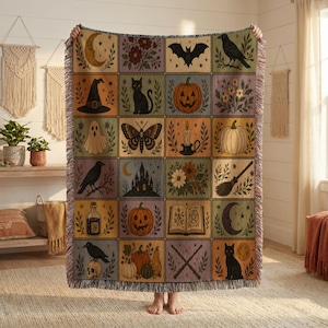 May include: A woven throw blanket featuring a grid of twenty rectangular panels with illustrations of a crescent moon, flowers, a bat, a raven, a witch hat, a black cat, a jack-o'-lantern, a ghost, a moth, a candle, a pumpkin, a castle, a broom, a potion bottle, a spellbook, and a skull.