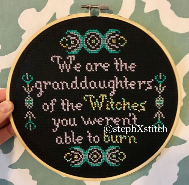 May include: Black embroidery hoop with a quote that reads "We are the granddaughters of the witches you weren't able to burn." The quote is surrounded by three triple moon symbols.