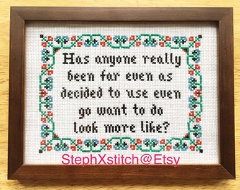 May include: Cross-stitch embroidery framed in a brown wood frame with a white background. The embroidery features a quote in black text: "Has anyone really been for even as decided to use even go want to do look more like?" The bottom of the embroidery includes the text "StephXstitch@Etsy".
