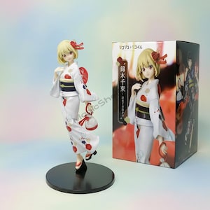 May include: A figurine of a woman in a white kimono with red floral accents, a black obi, and a matching hair ornament. The figure stands on a black base, with a box featuring the same character in a similar pose.