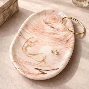 Può includere: Un set di tre tazze in ceramica con finitura opaca e macchiettata. Le tazze sono nei toni del crema, grigio chiaro e grigio scuro. Ogni tazza ha un design semplice e minimalista e un manico arrotondato.