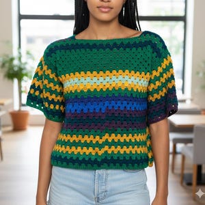 Puede incluir: Top de crochet de manga corta con un dise&ntilde;o de cuadrados de la abuela. La parte superior presenta rayas horizontales verdes, amarillas, azules y moradas. Tiene un escote cuadrado y mangas cortas acampanadas.