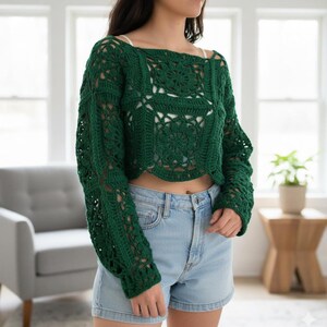 Puede incluir: Un top de ganchillo verde oscuro de manga larga, con cuello cuadrado y corte cropped. El dise&ntilde;o de ganchillo presenta patrones florales y detalles calados. El top se combina con shorts vaqueros.
