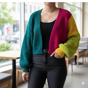 Puede incluir: Un c&aacute;rdigan corto con bloques de color en verde azulado, fucsia, amarillo y verde lima. El su&eacute;ter abierto tiene mangas largas ligeramente abullonadas y un dobladillo y pu&ntilde;os acanalados. La modelo lleva un top negro y vaqueros oscuros.