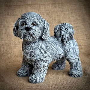 May include: A set of three ceramic mugs with a speckled, matte finish. The mugs are in shades of cream, light gray, and dark gray. Each mug has a simple, minimalist design and a rounded handle.