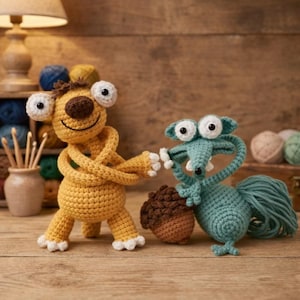 Puede incluir: Dos figuras de ganchillo, una amarilla y otra turquesa, sobre una superficie de madera. La figura amarilla tiene ojos grandes y brazos cruzados. La figura turquesa, parecida a una ardilla, sostiene una bellota marrón. Artesanía de ganchillo.