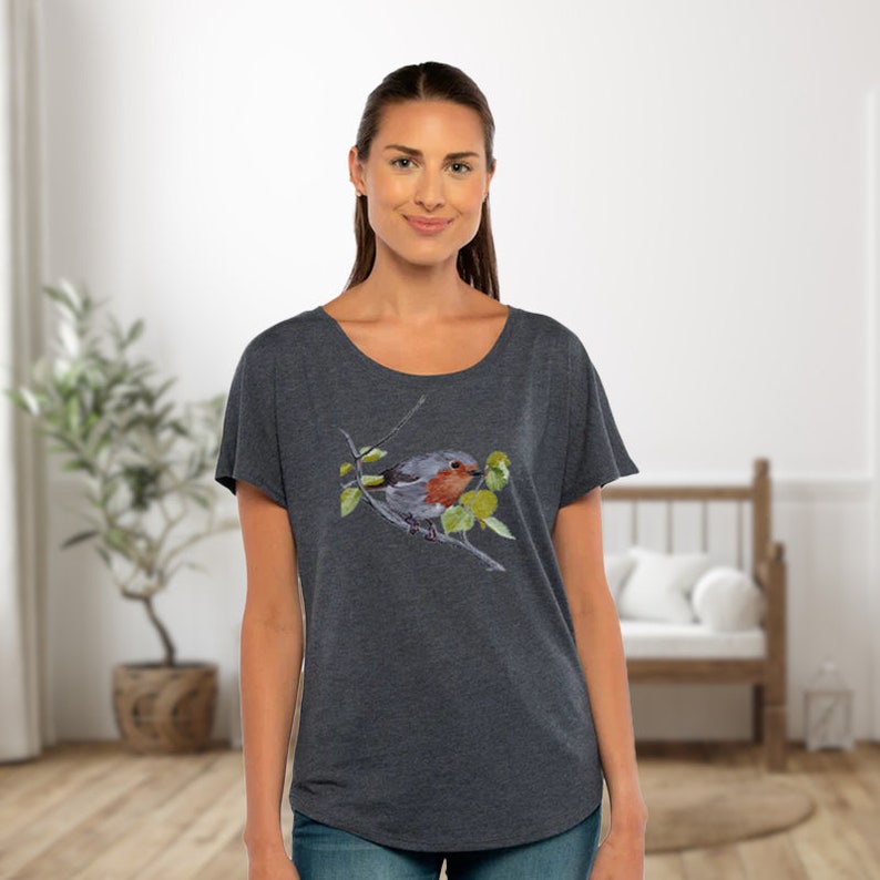 Puede incluir: Una camiseta gris oscuro jaspeada con una ilustraci&oacute;n de acuarela de un petirrojo posado en una rama con hojas verdes.