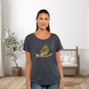 以下が含まれることがあります： 濃い青色のTシャツに、枝にとまっている茶色と緑色の鳥が描かれています。鳥は薄い茶色の胸と濃い茶色の頭をしています。
