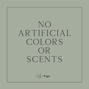Op de afbeelding: Vierkante afbeelding met een saliegroene achtergrond en een zwarte rand. De tekst "NO ARTIFICIAL COLORS OR SCENTS" is gecentreerd. De merknaam "Lily + Figs" staat onderaan.