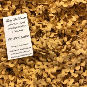 May include: Close-up of a pile of golden-yellow rick rack ribbon. The ribbon is hand-dyed and made of 100% cotton. A white tag in the image reads "Lady Dot Creates" and "Mother Lode". The ribbon is 7/32 inch wide.
