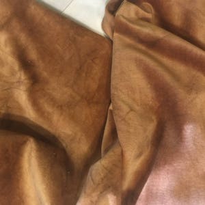 May include: Close-up of a brown velvet fabric with a soft, textured surface.