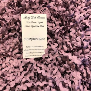 May include: A close-up of a pile of hand-dyed purple rickrack trim. The trim is made of 100% cotton and is 3 yards long. The card reads "Lady Dot Creates" and "Pumpkin Boo".