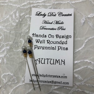 May include: Three decorative pins with white pearls and blue beads, labeled "Hands On Design Well Rounded Perennial Pins Autumn". The pins are handmade and sold by Lady Dot Creates.