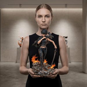 May include: A detailed anime-style figurine of a character with short dark hair, wearing a black outfit and a flowing cape, holding a long sword. The figure stands on a base of rocky debris and orange flames, with a skull visible among the rubble.