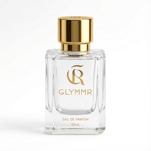 May include: A clear glass perfume bottle with a gold cap. The bottle has a rectangular shape with rounded edges. The brand name "GLYMMR" is printed in gold, along with the words "EAU DE PARFUM" and "50ML".
