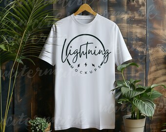 Hanging T-shirt mockup for Bella Canvas 3001, Gildan, Comfort Colors Shirts. White T-shirt on Hanger with Wooden Background and Plants