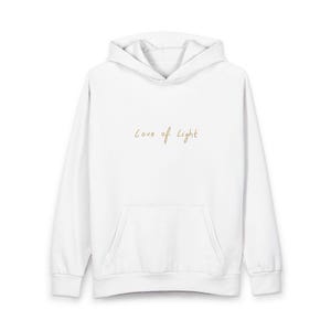 Puede incluir: Sudadera con capucha blanca con bolsillo delantero y cordón. La frase "Love of Light" está escrita en escritura dorada en el pecho. La sudadera tiene mangas largas y una capucha.