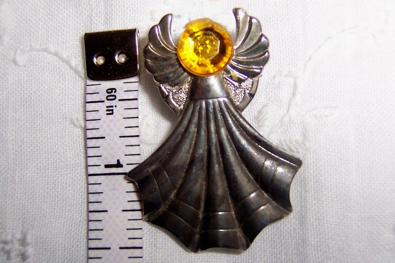 Vintage angel pin with yellow rhinestone. Silver metal. image 1