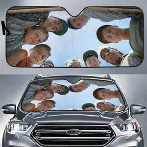 May include: A white ceramic mug with a black handle and the text "But First, Coffee" in a black, handwritten-style font. The mug is on a white surface.