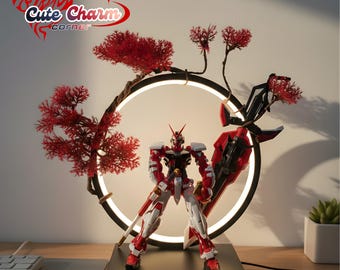 May include: A red and white robot action figure stands on a black base, framed by a circular light and red decorative branches. The lamp has a black frame and a warm white light. The overall design is reminiscent of Japanese art.