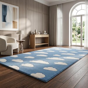 May include: A rectangular blue rug with white cloud shapes scattered across its surface. The rug is placed on a dark wood floor in a room with a neutral color palette. The rug adds a whimsical touch to the room's decor.