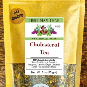 May include: A package of Cholesterol Tea from Herb Man Teas. The label includes the text "Organic" and lists ingredients like Rama Tulsi, Moringa, and Ginger. Net weight is 3 oz.