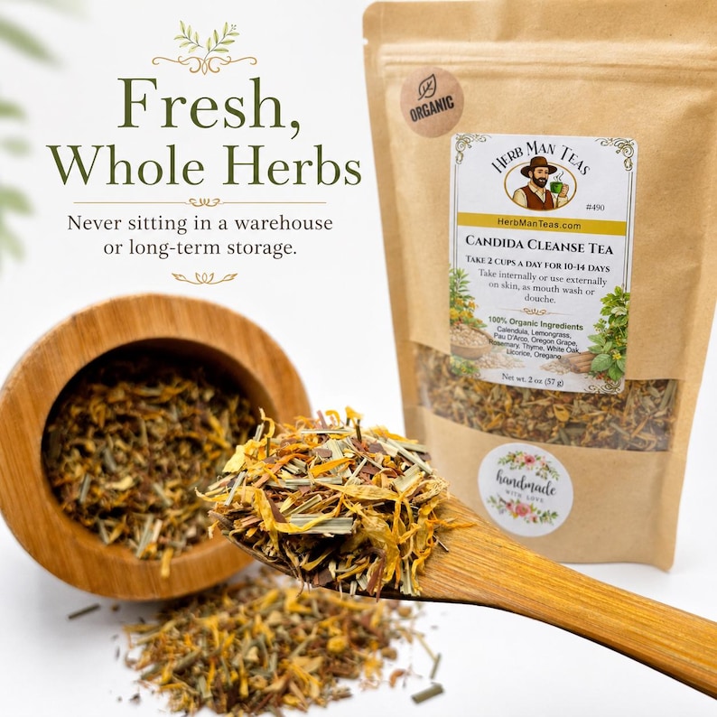 May include: A brown paper pouch of Candida Cleanse Tea with a label featuring a man holding a cup, text, and organic certification. A wooden spoon holds a blend of dried yellow and green herbs, with more loose herbs in a wooden bowl nearby.