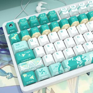 May include: A mechanical keyboard featuring a white frame and a custom keycap set in shades of teal, mint green, and white. The keys display letters, numbers, and symbols, with specific keys decorated with floral patterns, musical notes, and an anime-style character illustration on the escape key.