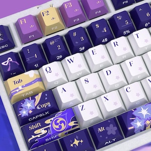 May include: A mechanical keyboard with a custom keycap set featuring a purple, white, and yellow color scheme. The keys display alphanumeric characters, function labels, and decorative floral and abstract patterns, including a small character icon on the escape key.