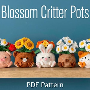 Puede incluir: Cinco macetas de animales de ganchillo, cada una con un diseño diferente: un cerdo, un oso, un conejo, un oso y un gato. Cada maceta está llena de flores de ganchillo de colores. El texto "Blossom Critter Pots" y "PDF Pattern" se muestra.