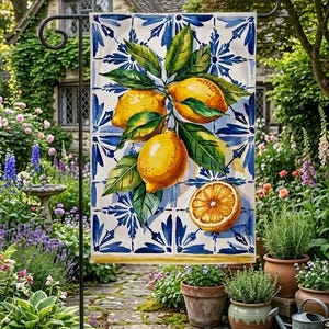 May include: A rectangular garden flag featuring a pattern of blue and white tiles as a background. The design displays a cluster of three bright yellow lemons with green leaves and one sliced lemon half, all centered on the tile-patterned fabric.
