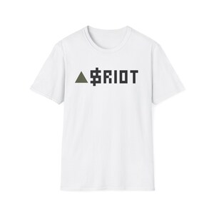 May include: A white short-sleeved t-shirt featuring a graphic on the chest. The graphic consists of a solid olive green triangle pointing upward, followed by the text $RIOT in a bold, black, pixelated, block-style font centered on the front.