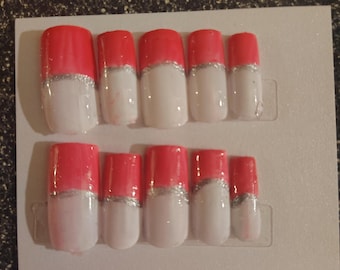 Uñas postizas rosas, blancas y plateadas.