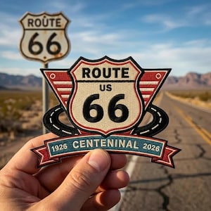 May include: An embroidered patch featuring the Route 66 shield logo in cream, black, and red. It includes black road graphics, red wings, and a blue banner at the bottom with the text 1926 CENTENINAL 2026 in white, celebrating the historic highway.
