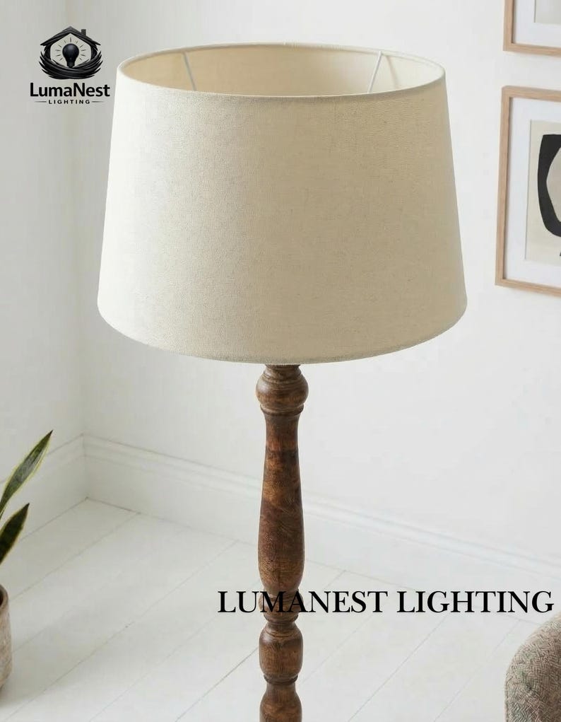May include: A tall floor lamp with a beige fabric shade and a dark brown wooden base. The lamp has a classic design and is suitable for living rooms or bedrooms. The text "LumaNest Lighting" is visible at the bottom of the lamp.