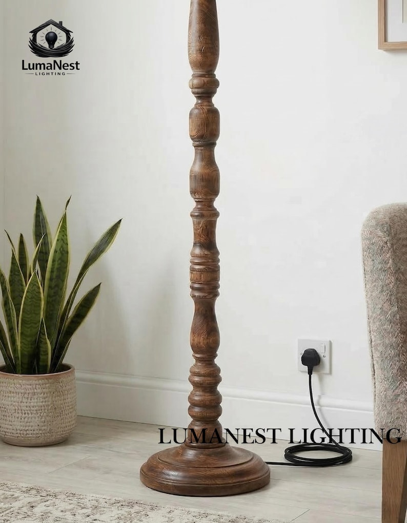 May include: A wooden floor lamp with a dark brown finish. The lamp has a turned wood design and a round base. The brand name "LumaNest Lighting" is printed on the base. A black power cord is connected to a wall outlet.