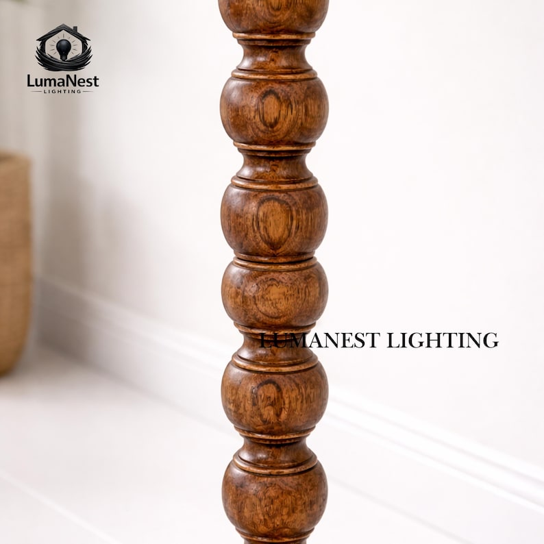May include: A close-up of a wooden lamp post with a turned design. The post is a warm brown color and has a series of rounded sections. The text "LumaNest Lighting" is visible in the image.