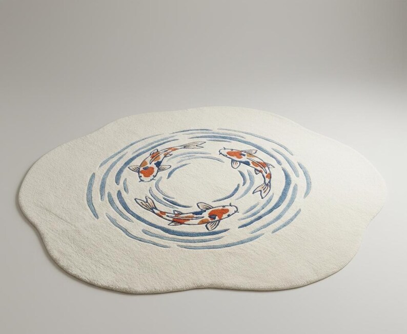 May include: A cream-colored, oval rug featuring a design of three koi fish swimming in a circle. The fish are orange, white, and black, with blue water lines. The rug has a soft, textured appearance.