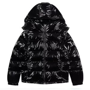 May include: A glossy black puffer jacket with a hood. The jacket has a full-length zipper and a small logo on the chest. The jacket is designed for warmth and protection from the elements.
