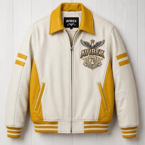 May include: A cream and mustard yellow leather jacket featuring a full-length front zipper, a mustard collar, and striped ribbed cuffs and hem. The chest displays an embroidered emblem with the text AVIREX 75 AVIATOR'S KING and a winged crest.