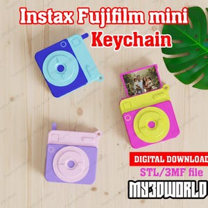 Puede incluir: Tres réplicas de llaveros Instax Fujifilm mini de colores. Uno es azul y celeste, otro rosa y amarillo, y el tercero morado y rosa. El llavero rosa y amarillo tiene una pequeña foto en su interior. El texto "Instax Fujifilm mini Keychain" está en la parte superior.