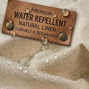 May include: Close-up of a brown leather tag with the words "PREMIUM WATER REPELLENT NATURAL LINEN DURABLE & DECORATIVE" printed in black. Water droplets are visible on the tag and the beige linen fabric.