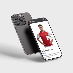 May include: Two smartphones, one dark grey and one black, showing a red and white football shirt. The shirt is on a website with the text "24/25 HOME KIT - MEN". The phone has a triple-lens camera.