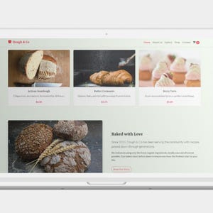 K&ouml;nnte beinhalten: Ein Laptop-Bildschirm zeigt eine B&auml;ckerei-Website mit Bildern von Sauerteigbrot, Croissants und Beeren-T&ouml;rtchen. Die Website enth&auml;lt den Text "Baked with Love" und Produktbeschreibungen.